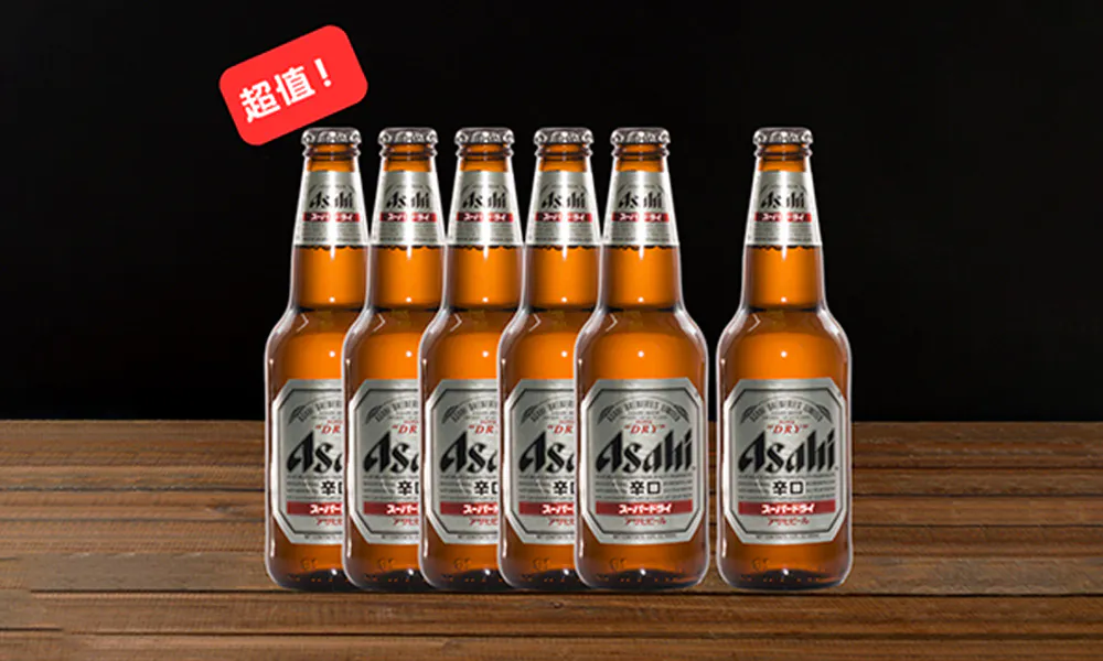 Six Asahi Super Dry beer bottles lined up, red "Great Value!" tag top left, displayed on wooden table with dark backdrop.